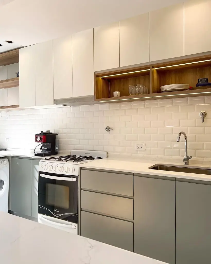 Cocina con bajo mesada verde salvia, alacenas beige y mesada de cuarzo blanco
