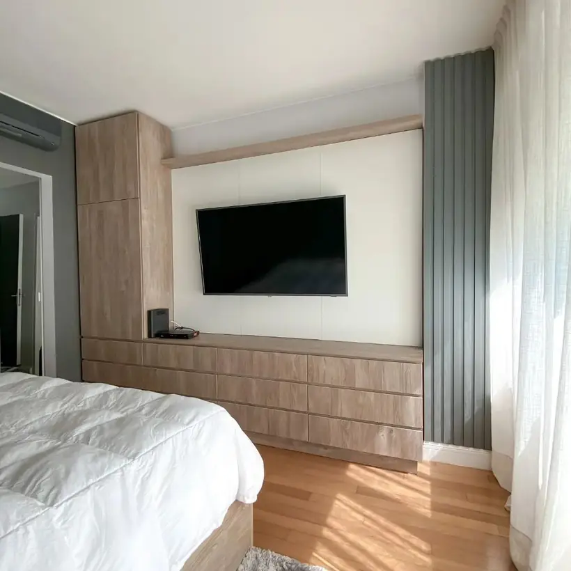 Dormitorio con mueble de TV, cajonera larga en madera y panel ranurado verde