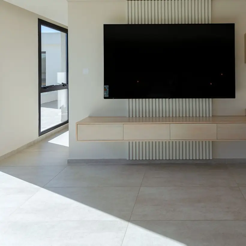 Rack de TV flotante de madera clara con panel ranurado beige