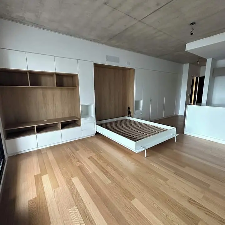 Monoambiente con mueble integral: biblioteca, guardado y cama rebatible abierta