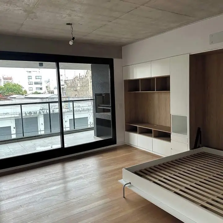 Monoambiente con mueble de pared completa y cama rebatible abierta