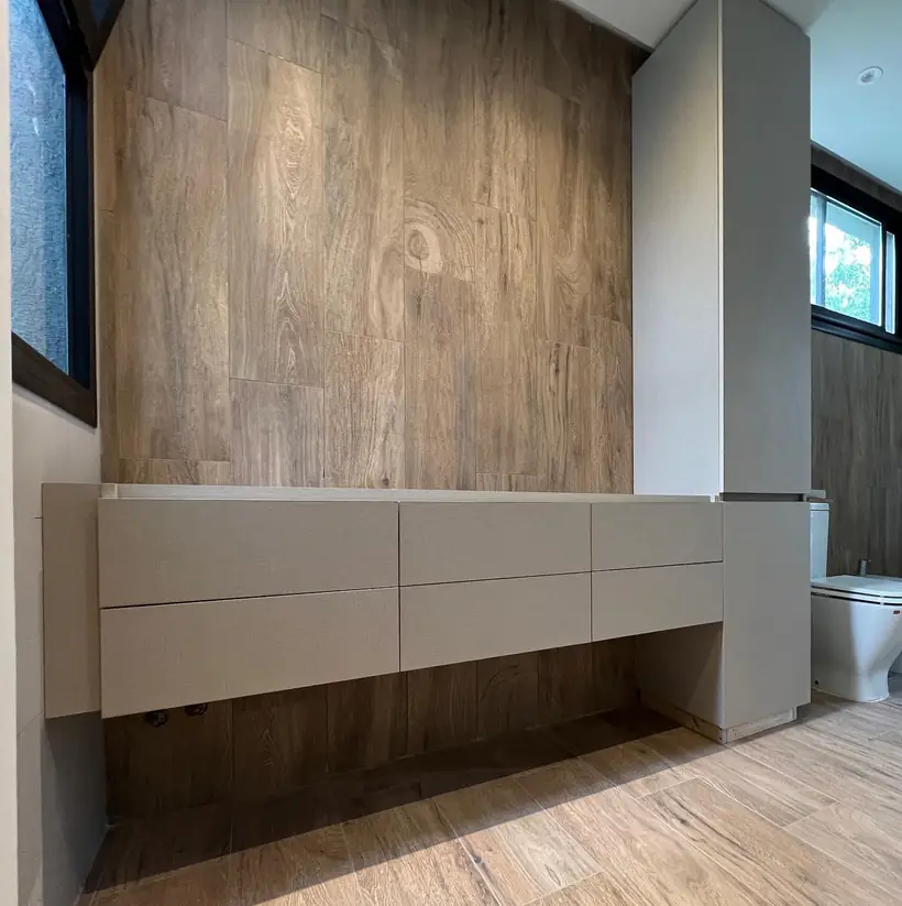 Vanitory suspendido de seis cajones sobre pared de porcelánico símil madera