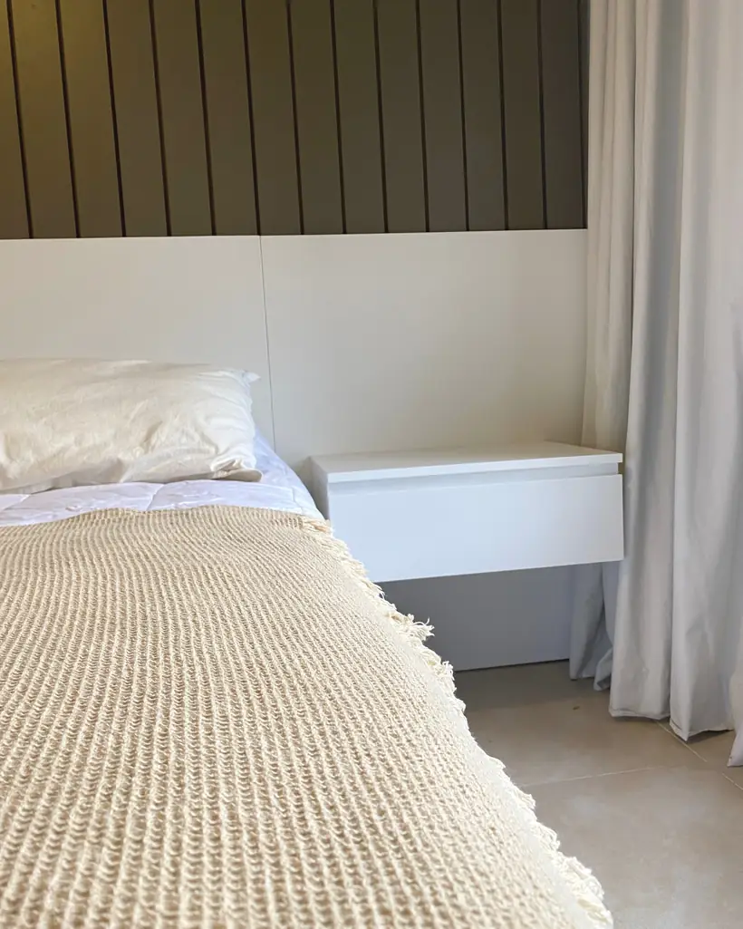 Mesa de luz flotante blanca contra respaldo panelado
