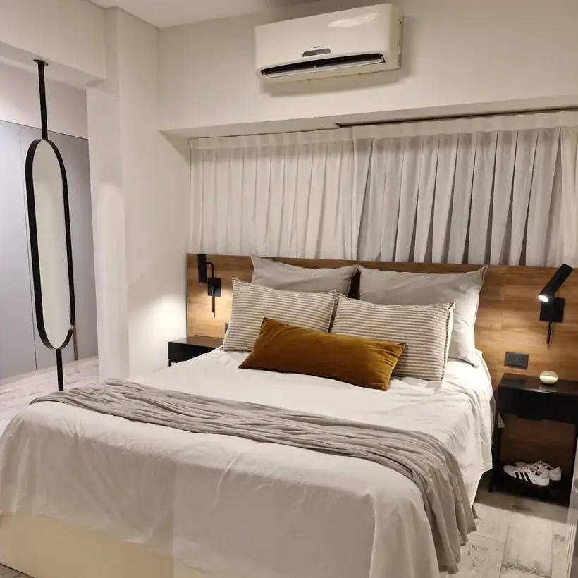 Dormitorio con respaldo de madera y placard gris